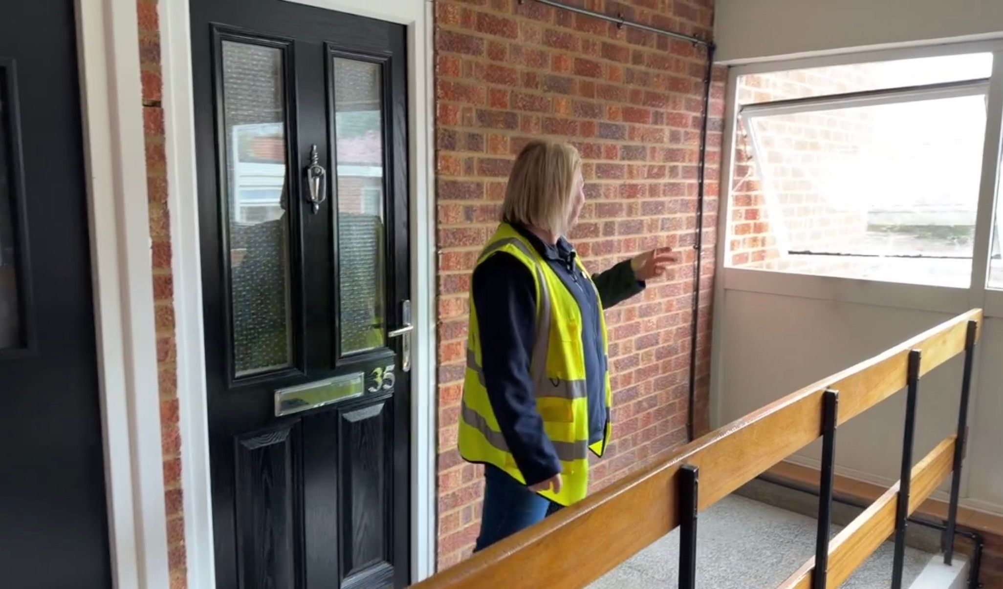 Image of site manager pointing towards an open window